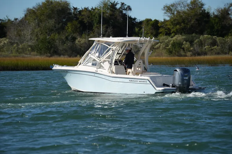 Slide: The Image of 2022 Grady-White Freedom 235 boat cruising on a scenic waterway. - 13