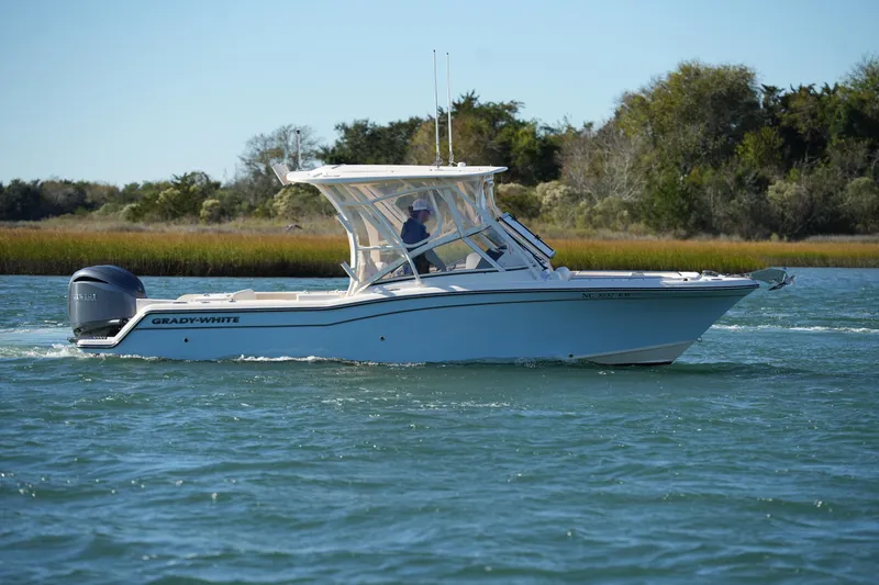 Slide: The Image of 2022 Grady-White Freedom 235 boat cruising on a scenic waterway. - 14