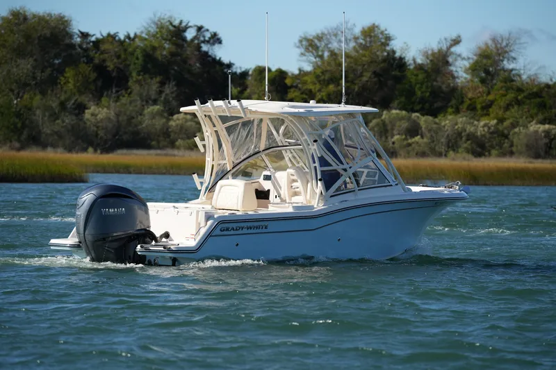 Slide: The Image of 2022 Grady-White Freedom 235 boat cruising on a scenic waterway. - 16