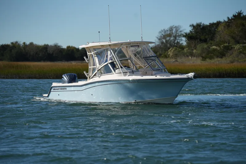Slide: The Image of 2022 Grady-White Freedom 235 boat cruising on a serene waterway. - 2