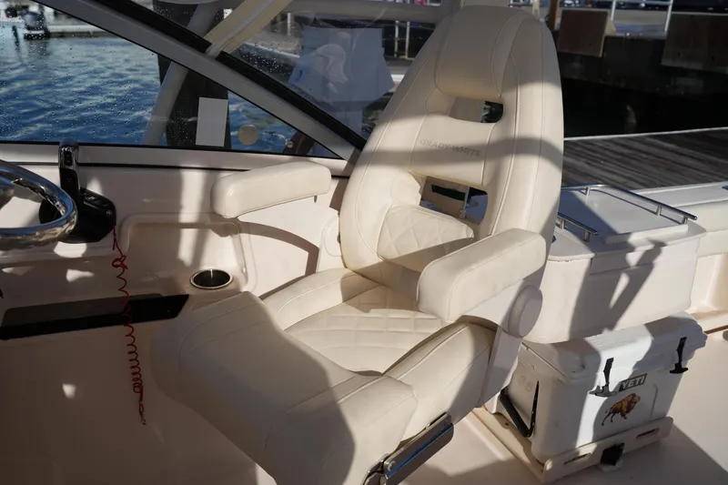Slide: The Image of Captain's chair on 2022 Grady-White Freedom 235 boat, featuring luxurious beige upholstery. - 24
