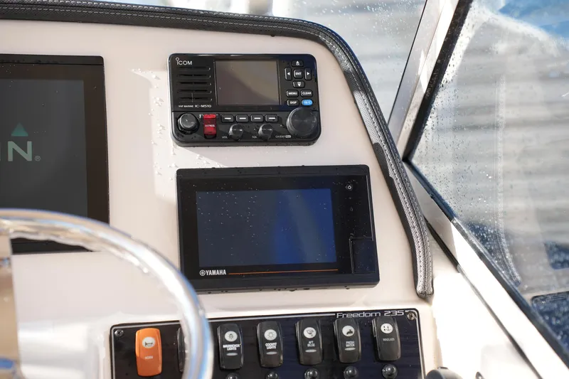 Slide: The Image of 2022 Grady-White Freedom 235 boat dashboard with navigation and control panels. - 28