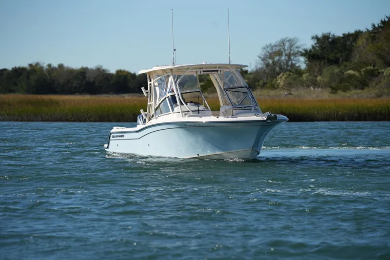 Slide: The Image of 2022 Grady-White Freedom 235 boat cruising on a serene waterway. - 3