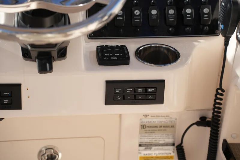 Slide: The Image of Control panel of 2022 Grady-White Freedom 235 boat with steering wheel and switches. - 30