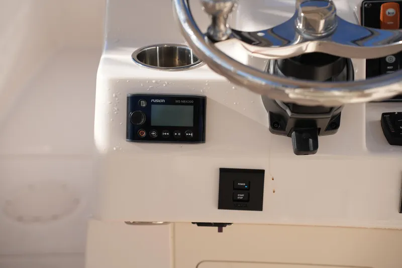 Slide: The Image of 2022 Grady-White Freedom 235 boat dashboard with steering wheel and control panel. - 31