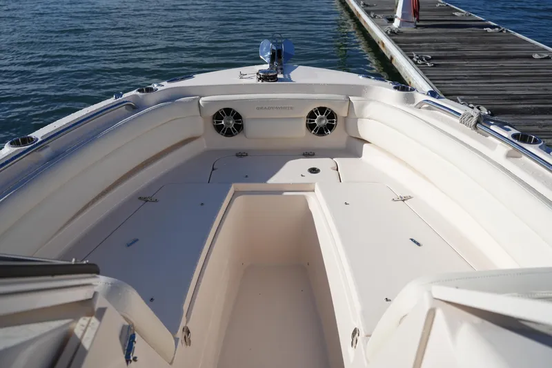 Slide: The Image of 2022 Grady-White Freedom 235 boat interior at dock, showcasing seating and storage. - 37