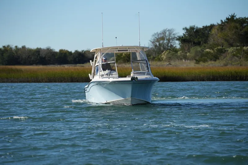 Slide: The Image of 2022 Grady-White Freedom 235 boat cruising on a scenic waterway. - 4