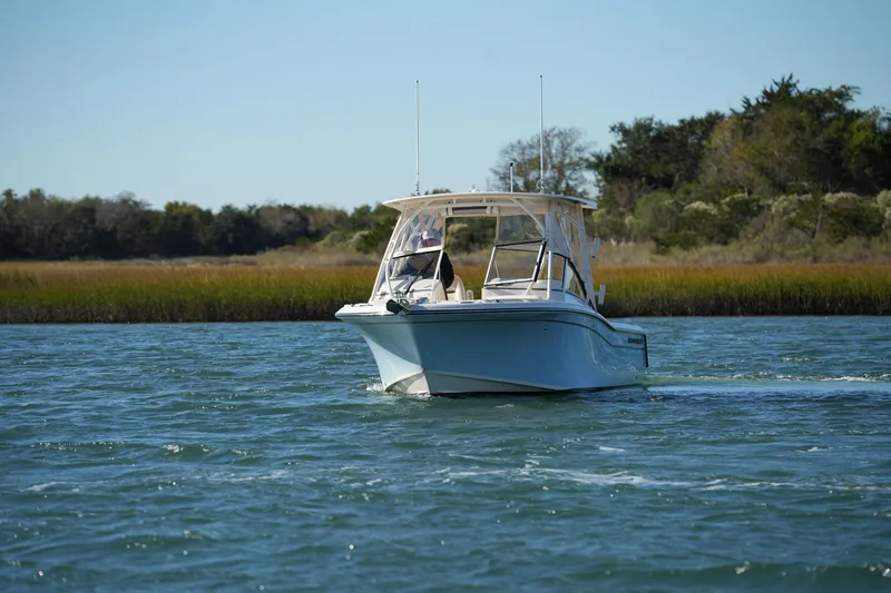 Slide: The Image of 2022 Grady-White Freedom 235 boat cruising on a scenic waterway. - 5