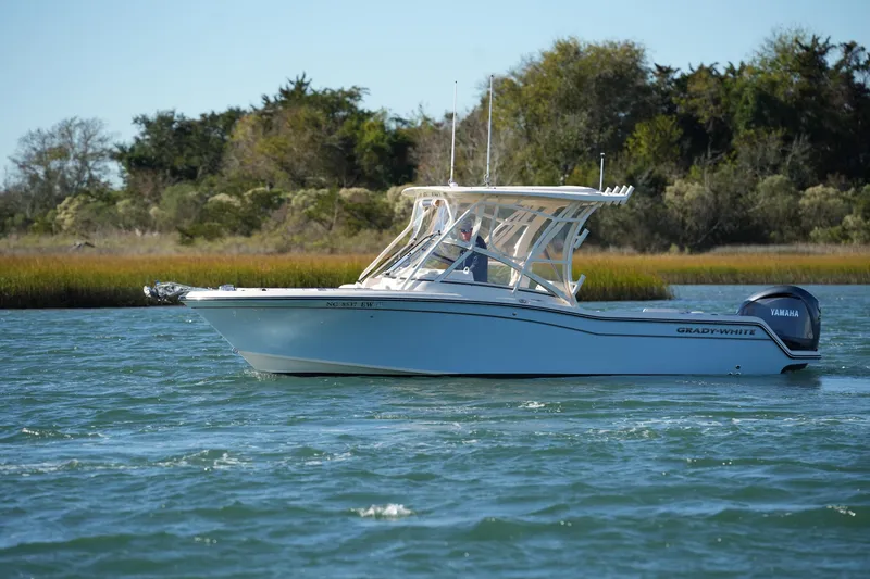 Slide: The Image of 2022 Grady-White Freedom 235 boat cruising on a scenic waterway. - 9