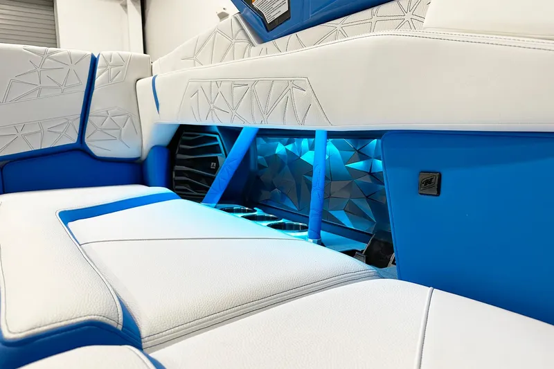 Slide: The Image of 2025 Nautique Super Air Nautique G23 Paragon interior with blue LED lighting and white seating. - 12