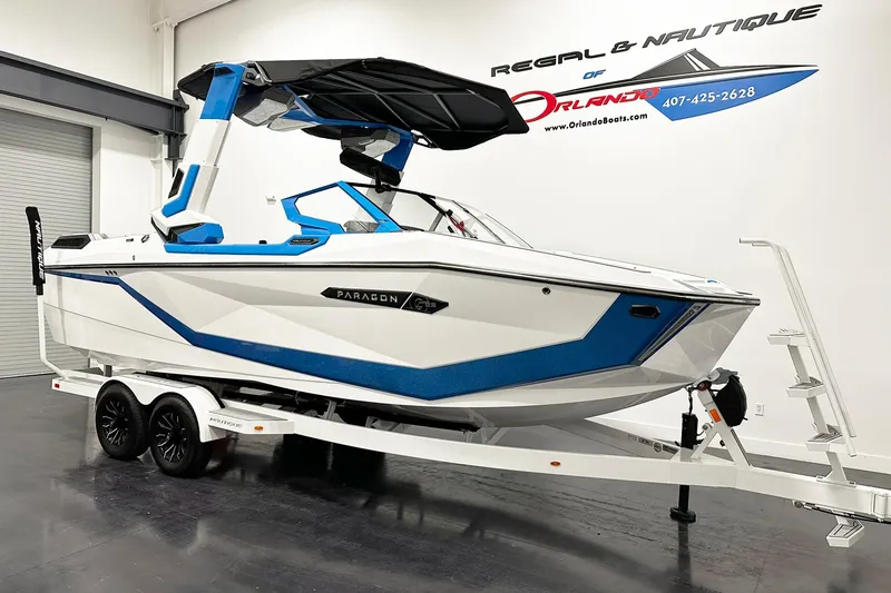 Slide: The Image of 2025 Nautique Super Air Nautique G23 Paragon boat on trailer in showroom. - 2