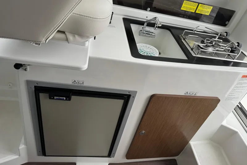 Slide: The Image of Compact kitchen area in a 2020 Beneteau Antares 8 boat, featuring a sink and stove. - 13