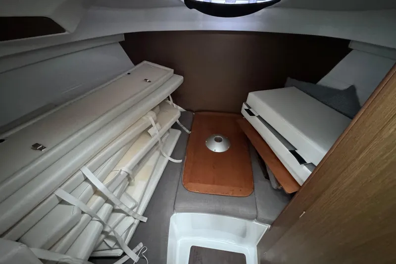 Slide: The Image of Interior cabin of 2020 Beneteau Antares 8 with folded cushions and wooden table. - 17
