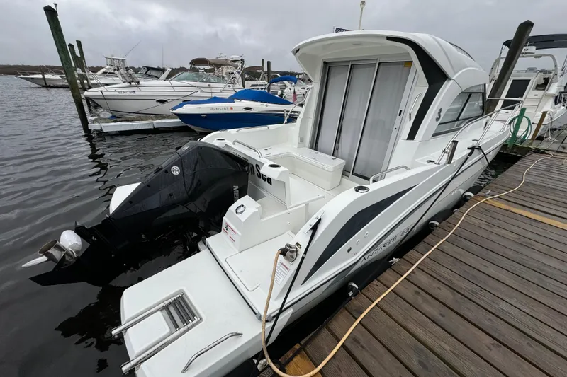 Slide: The Image of 2020 Beneteau Antares 8 docked, featuring sleek design and powerful outboard motor. - 3