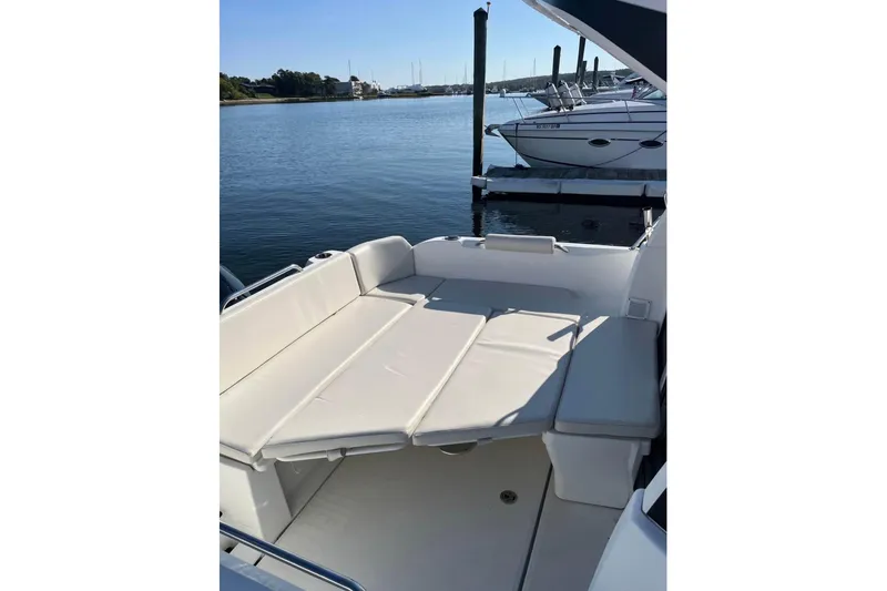 Slide: The Image of 2020 Beneteau Antares 8 boat with spacious seating area, docked by calm waters. - 6