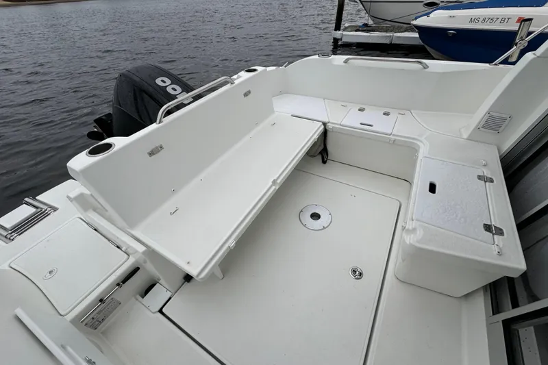 Slide: The Image of 2020 Beneteau Antares 8 boat deck with seating and storage, docked by the water. - 9