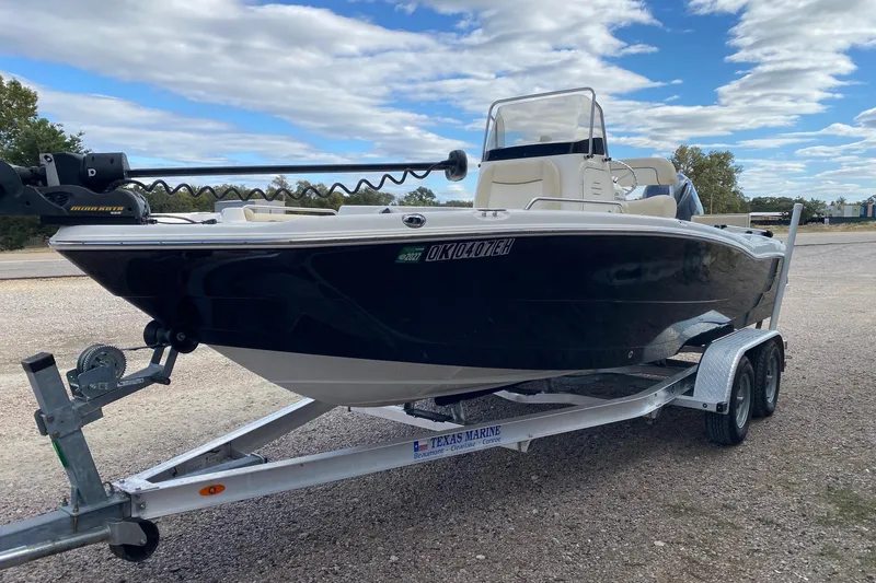 Slide: The Image of 2018 NauticStar 211 Coastal boat on trailer under a partly cloudy sky. - 3