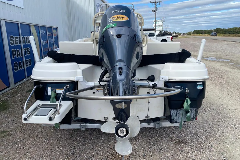 Slide: The Image of 2018 NauticStar 211 Coastal boat with outboard motor, parked on gravel. - 5