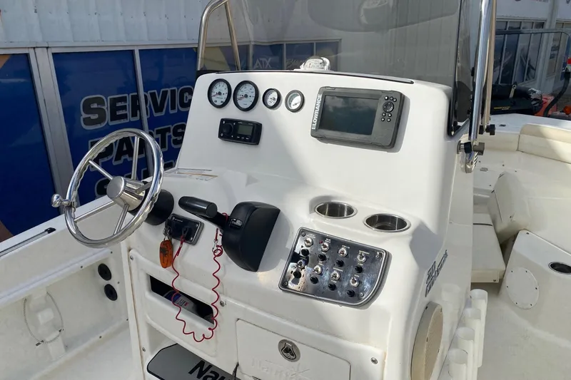 Slide: The Image of 2018 NauticStar 211 Coastal boat dashboard with steering wheel and navigation controls. - 7