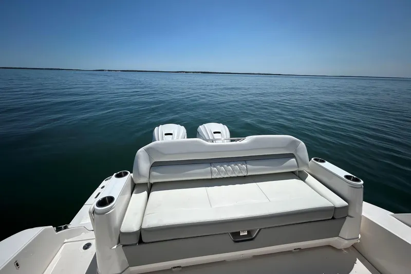 Slide: The Image of 2025 Regal 36 XO boat with rear seating, overlooking calm ocean waters. - 11