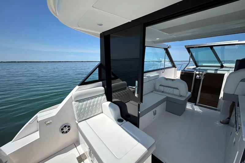 Slide: The Image of 2025 Regal 36 XO luxury boat interior with seating, open water view. - 13