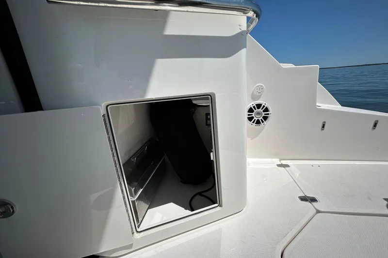 Slide: The Image of 2025 Regal 36 XO yacht storage compartment with open hatch, revealing interior details. - 16