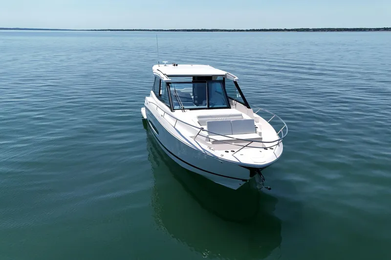 Slide: The Image of 2025 Regal 36 XO boat on calm water, showcasing sleek design and modern features. - 2