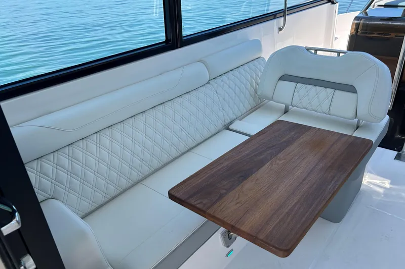 Slide: The Image of Luxurious seating area on 2025 Regal 36 XO yacht with elegant wood table. - 24