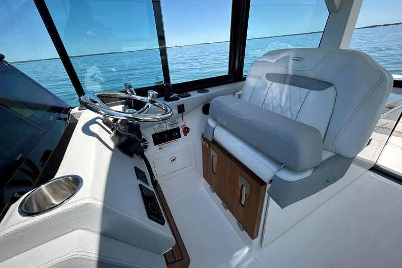 Slide: The Image of 2025 Regal 36 XO boat interior with steering wheel and luxurious seating. - 27