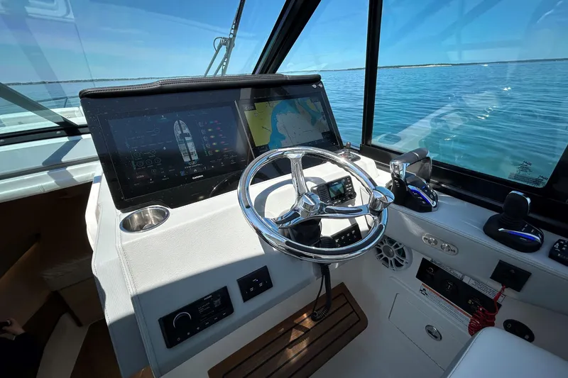 Slide: The Image of 2025 Regal 36 XO boat helm with advanced navigation system and ocean view. - 28