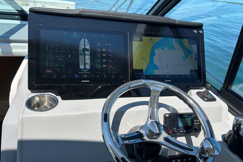 Slide: The Image of 2025 Regal 36 XO boat dashboard with Garmin navigation screens and steering wheel. - 29