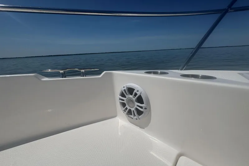 Slide: The Image of Regal 36 XO 2025 boat deck with speaker and cup holders, overlooking calm water. - 32