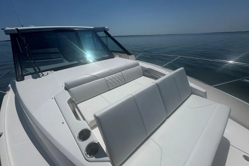 Slide: The Image of 2025 Regal 36 XO boat with sleek white seating on calm water. - 41
