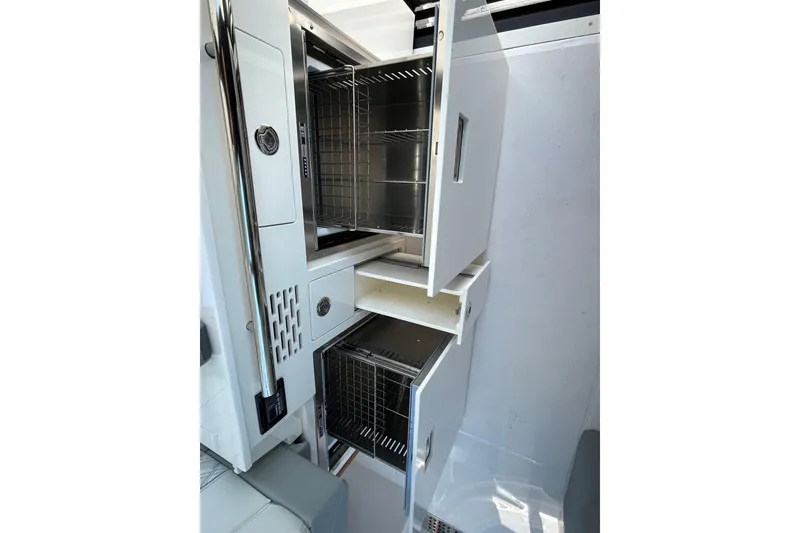 Slide: The Image of 2025 Regal 36 XO yacht interior storage compartments with open doors and wire baskets. - 48