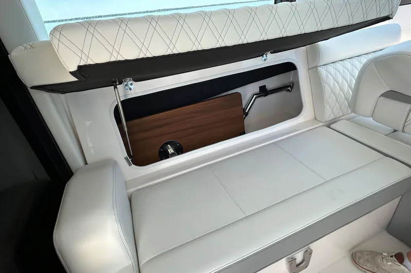 Slide: The Image of 2025 Regal 36 XO boat interior storage compartment with white cushioned seating. - 51