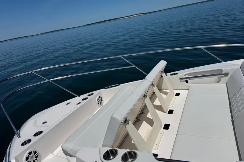 Slide: The Image of 2025 Regal 36 XO boat interior with white seating on calm water. - 64