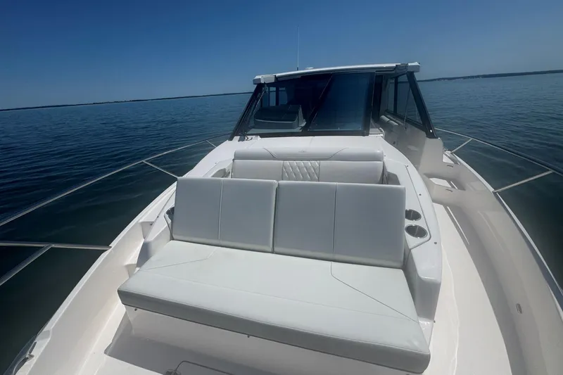 Slide: The Image of 2025 Regal 36 XO boat with sleek white seating on calm water. - 65