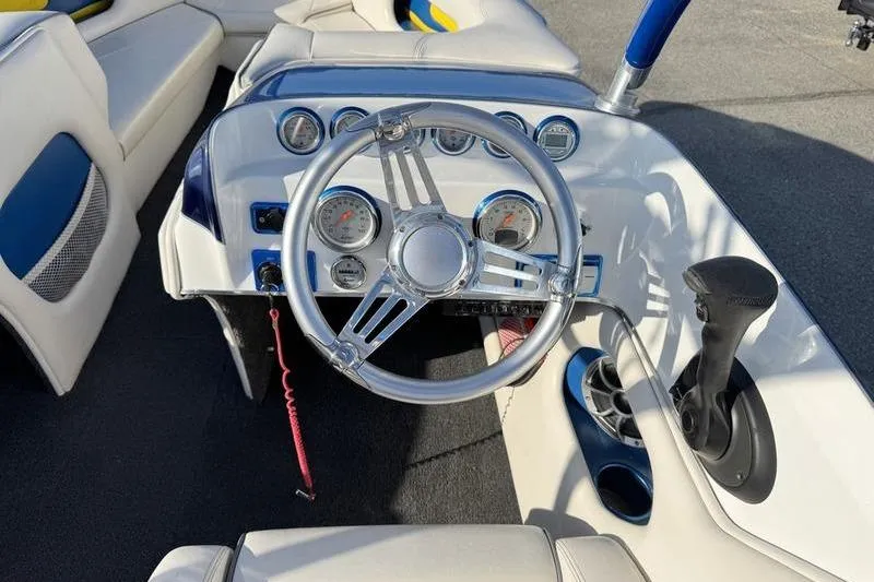 Slide: The Image of Steering wheel and dashboard of 2013 Caliber 1 230 Velocity boat, featuring gauges and controls. - 11