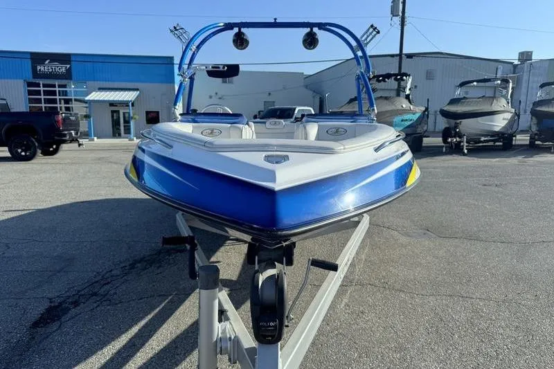 Slide: The Image of 2013 Caliber 1 230 Velocity boat in a marina, blue and white design. - 5