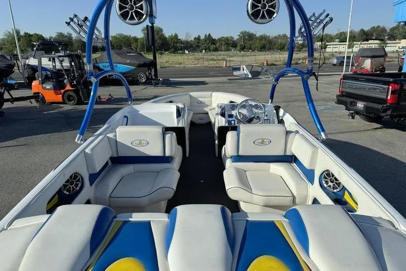 Slide: The Image of 2013 Caliber 1 230 Velocity boat with blue and white interior, parked outdoors. - 7