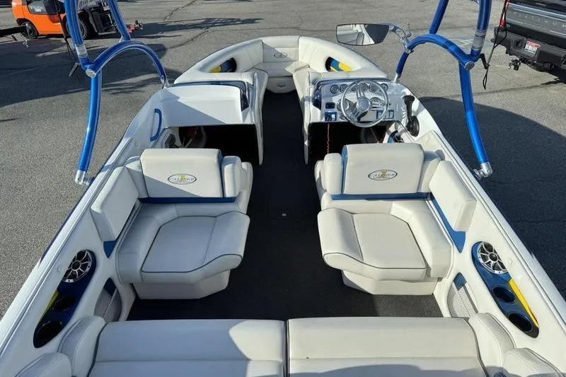 Slide: The Image of 2013 Caliber 1 230 Velocity boat interior with white seating and blue accents. - 8