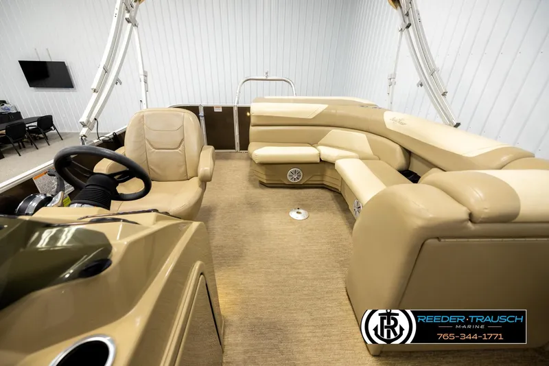 Slide: The Image of 2022 SunChaser 20 Geneva CRS pontoon boat interior with beige seating and steering console. - 14