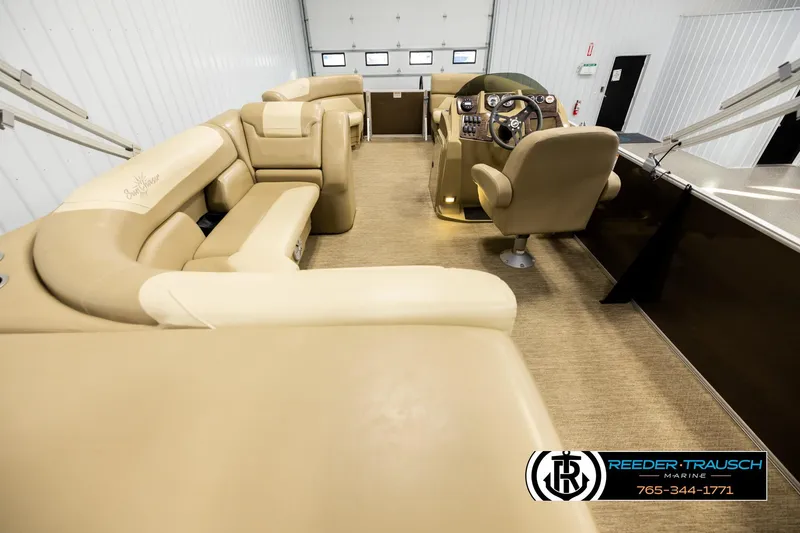 Slide: The Image of 2022 SunChaser 20 Geneva CRS pontoon boat interior with beige seating and steering console. - 16