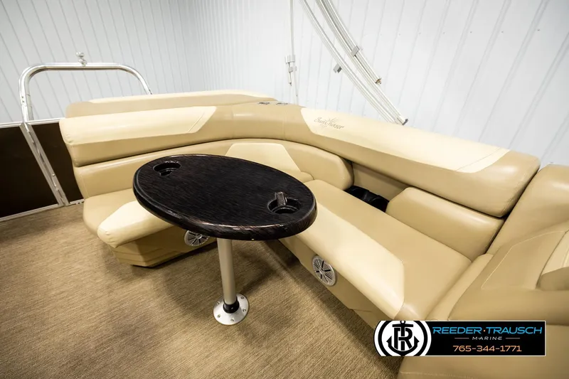 Slide: The Image of 2022 SunChaser 20 Geneva CRS boat interior with beige seating and dark wood table. - 21