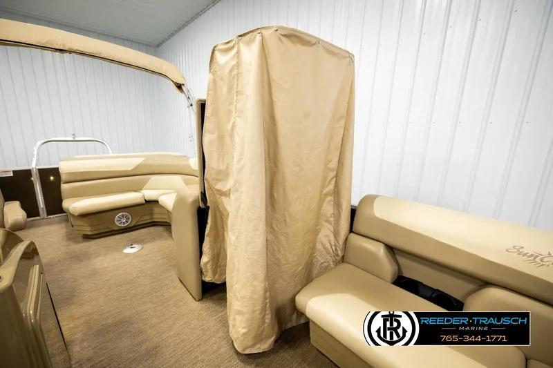 Slide: The Image of 2022 SunChaser 20 Geneva CRS boat interior with beige seating and canopy in showroom. - 25