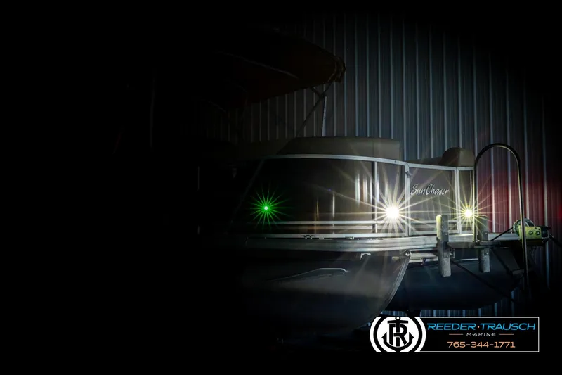 Slide: The Image of 2022 SunChaser 20 Geneva CRS pontoon boat with illuminated lights in a dimly lit setting. - 4