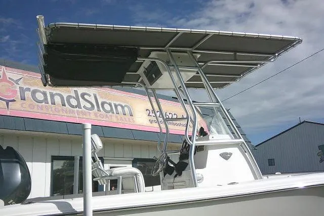 Slide: The Image of 2014 Tidewater 196 CC Adventure boat with T-top, parked near Grand Slam sign. - 5