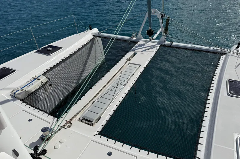 Slide: The Image of 2021 Outremer 51 catamaran deck with netting over blue ocean water. - 11