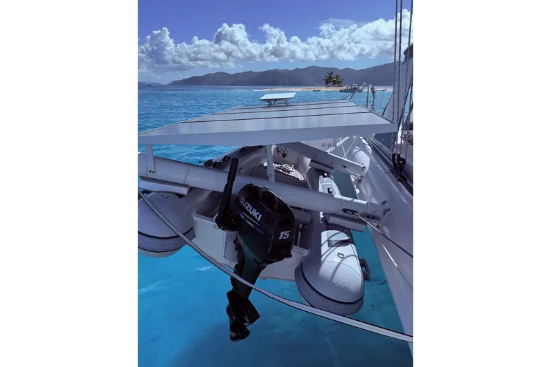 Slide: The Image of Outremer 51 catamaran with Suzuki outboard motor, anchored in clear blue waters, 2021 model. - 12