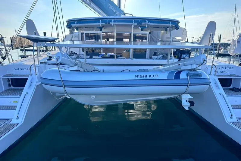 Slide: The Image of 2021 Outremer 51 catamaran with Highfield dinghy at marina. - 2
